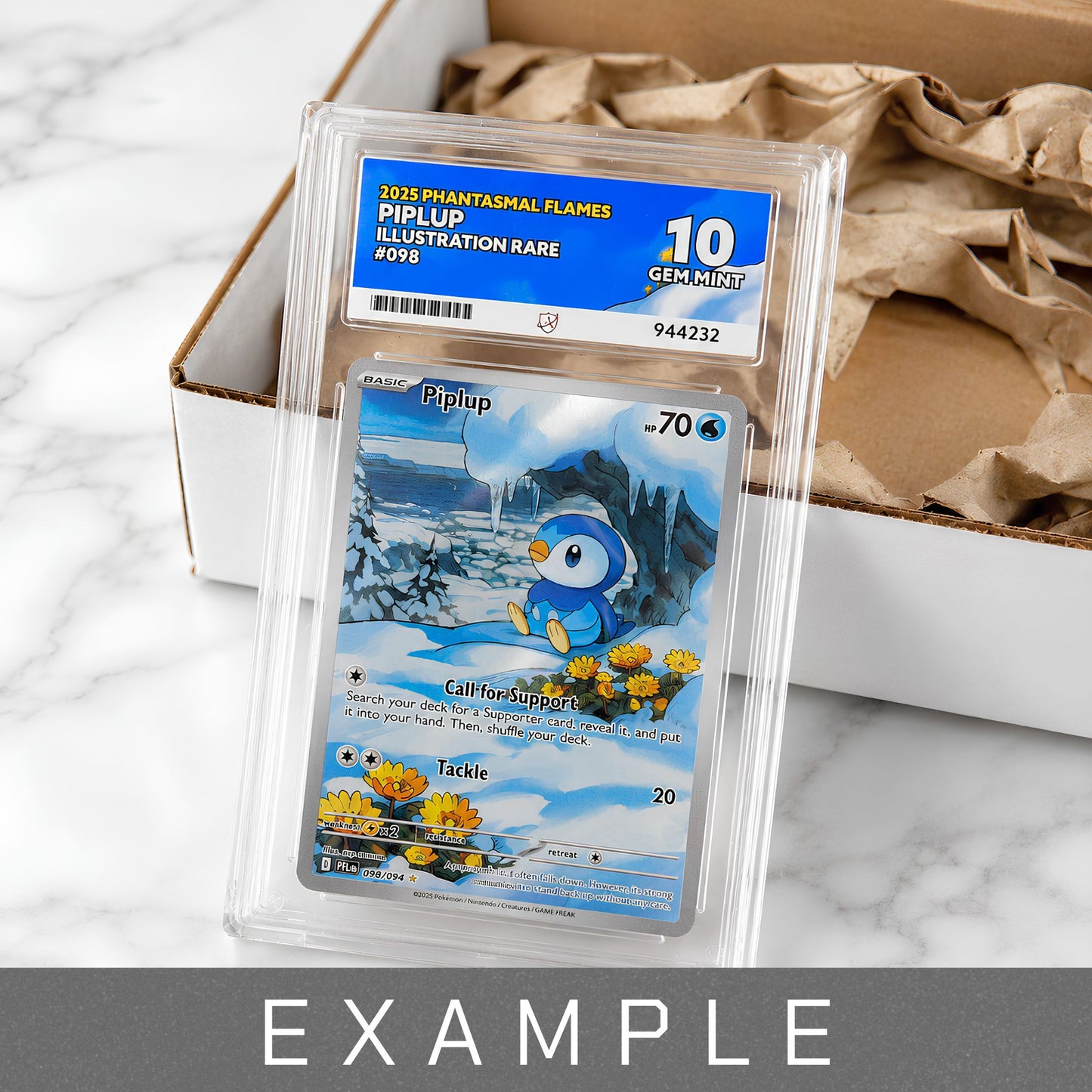 A graded Piplup Gem Mint 10 trading card in a clear plastic holder with a blue and white Gem Mint 10 label, placed on top of a cardboard box with brown packing paper. The card artwork shows a blue bird character in a snowy landscape.