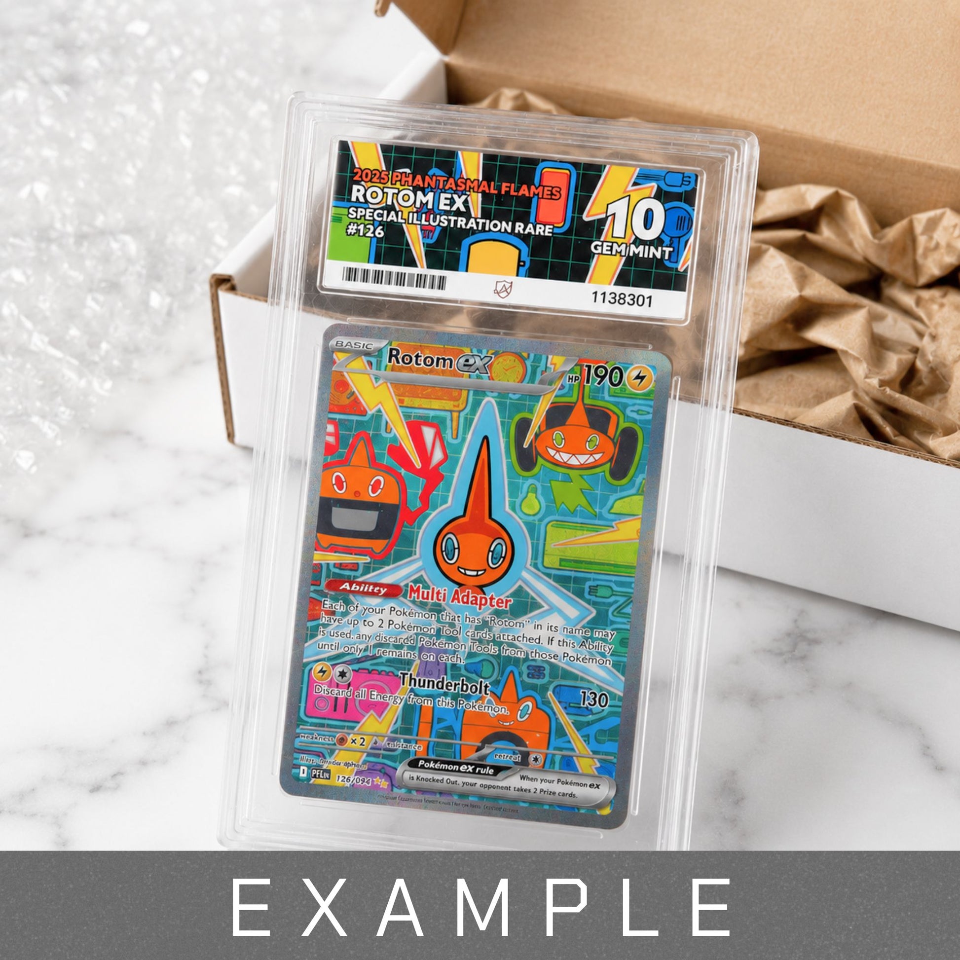 A Graded Rotom ex Gem Mint 10 trading card graded and encapsulated in a clear plastic holder, placed in front of an open cardboard box with bubble wrap. The card features Rotom and a blue background with colorful illustrated details.